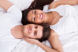 Young Couple Lying On Mattress Topper